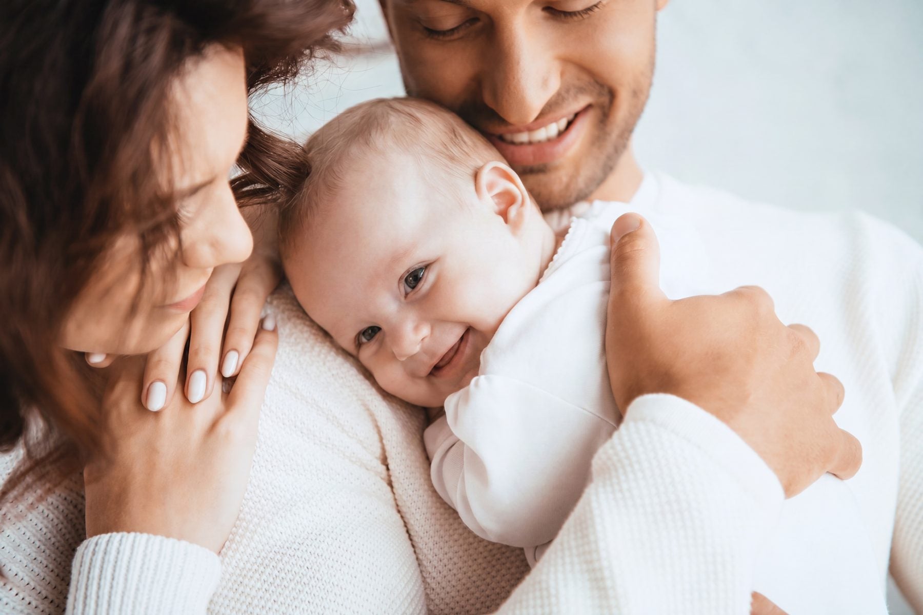 Parents cuddling their smiling baby